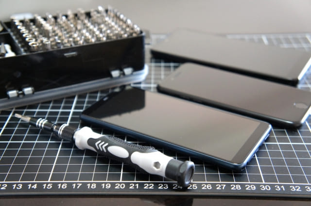 iPhoneと修理用工具のイメージ