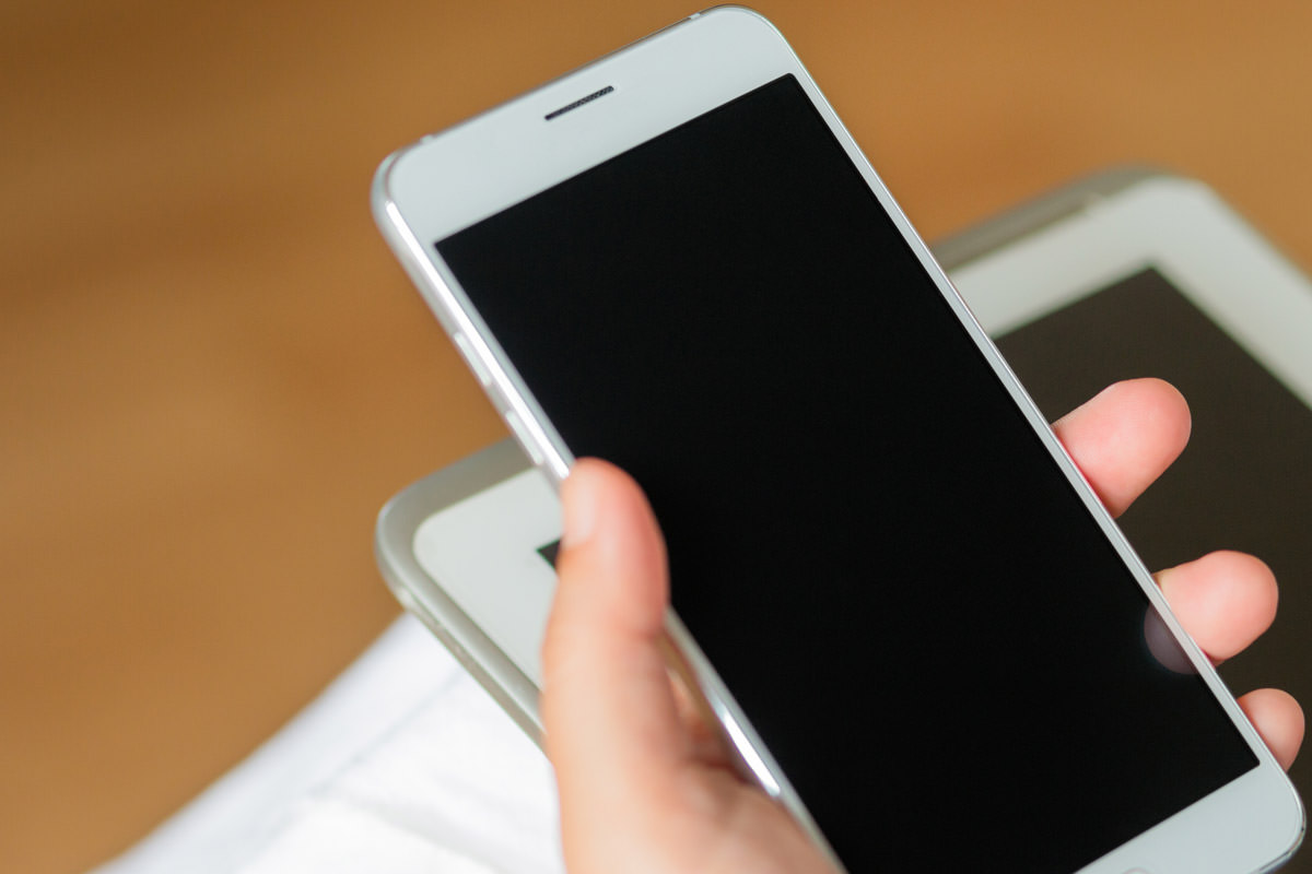 iPhoneの音量ボタンを押しているイメージ写真