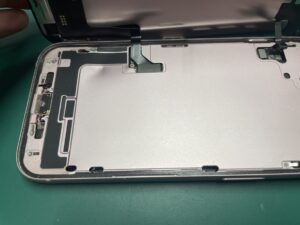 画面パネルを開いて内部に破損が無いか確認しているiPhone15