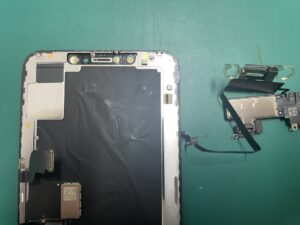 イヤースピーカーを慎重に取り外しFaceIDケーブルを痛めないよう作業しているiPhoneXSMAX