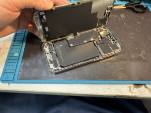 スマホスピタル横浜関内店でiPhone 15 Proの画面を慎重に剥がし内部電池を外す様子