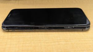iPhone Xの右側面から撮影した、画面がバッテリーの膨張により浮き上がっている様子。