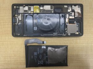 Google Pixel 6の有機ELディスプレイを開き、内部のミドルフレームと膨張したバッテリーを取り外した分解状態