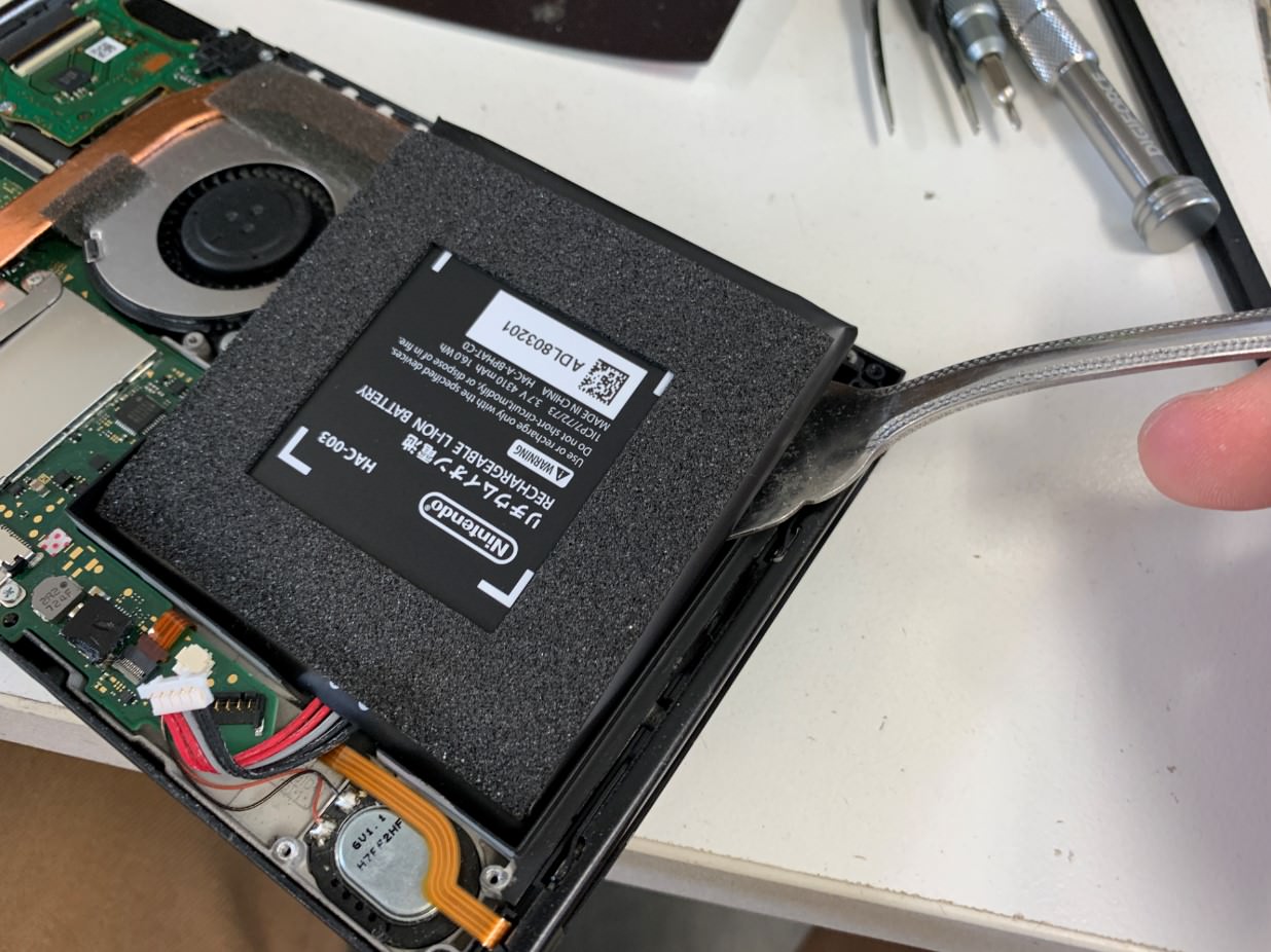 バッテリーを本体から剥がそうとしているバッテリー劣化したswitch