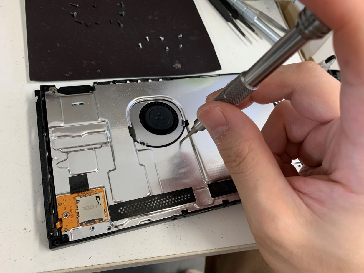 本体内部の銀板を外そうとしているバッテリー劣化したswitch