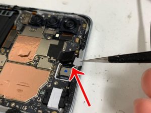 内カメラと画面の間にフィルムを挟もうとしているRedmi Note 10 JE