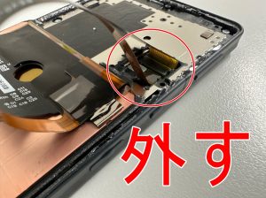 画面パーツのコネクタを外そうとしている画面が割れたAQUOS sense6
