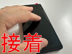 新品の画面パーツを本体フレームに接着しているAQUOS sense6