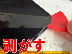 フレームからフロントパネルを剥がしている画面交換中のiPhone 16 Pro