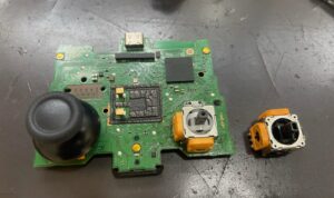 PS5コントローラーの基板からスティックユニットを取り外している様子