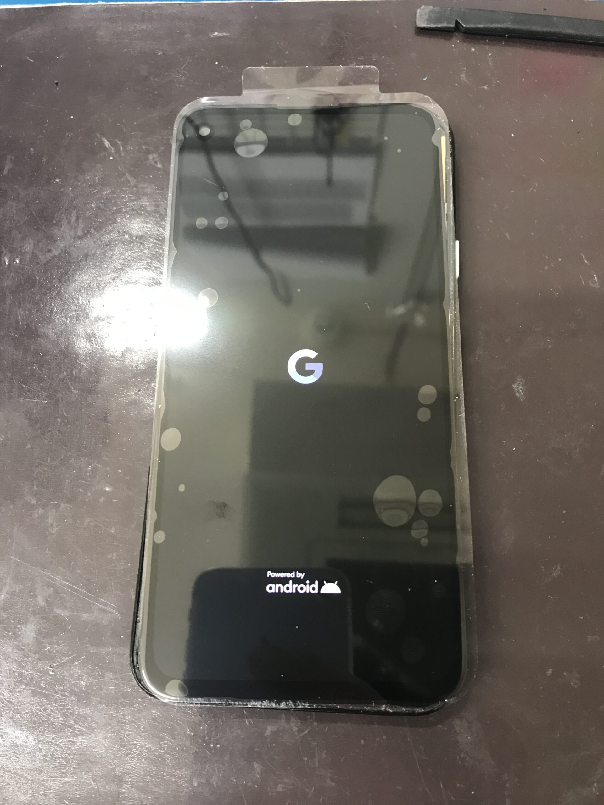 Google Pixel 4aの画面交換中に新しいディスプレイを仮付けして起動確認を行う様子