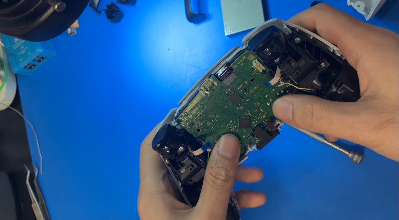DualSenseのメイン基板につながる4本のフレックスケーブルを取り外した状態